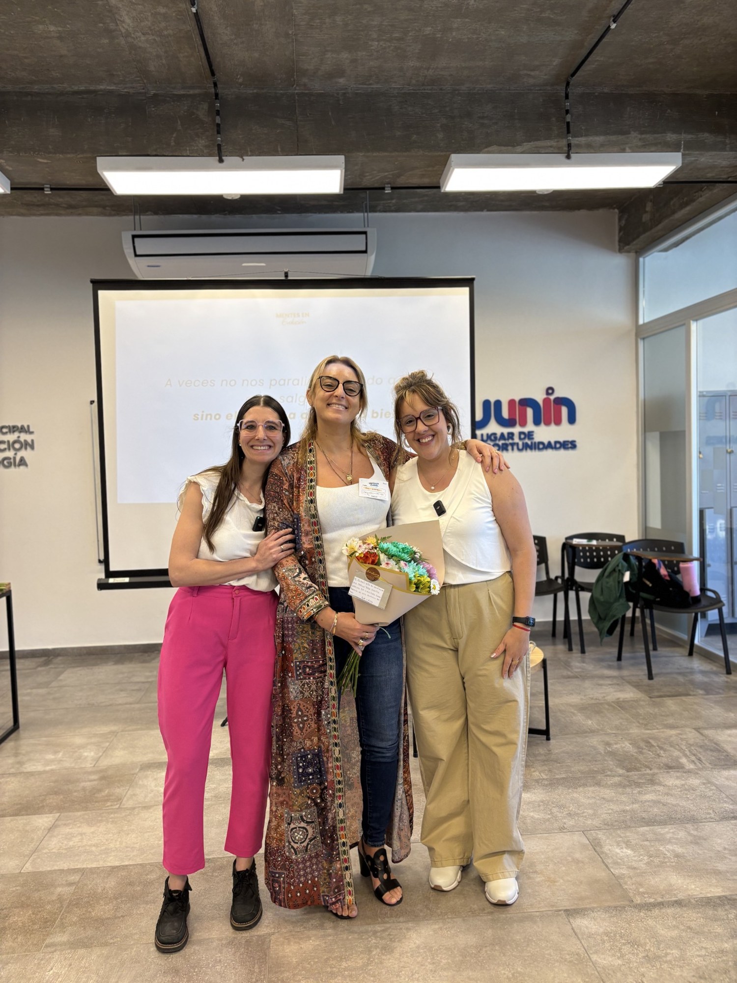 Tres participantes abrazadas y sonriendo en Mentes en Evolución 2025