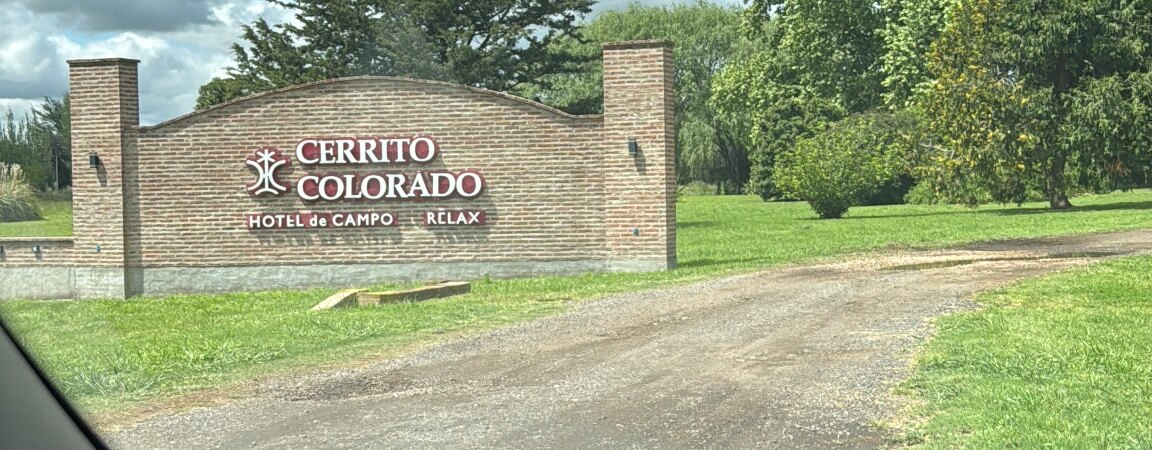 Entrada al Hotel Cerrito Colorado entre jardines